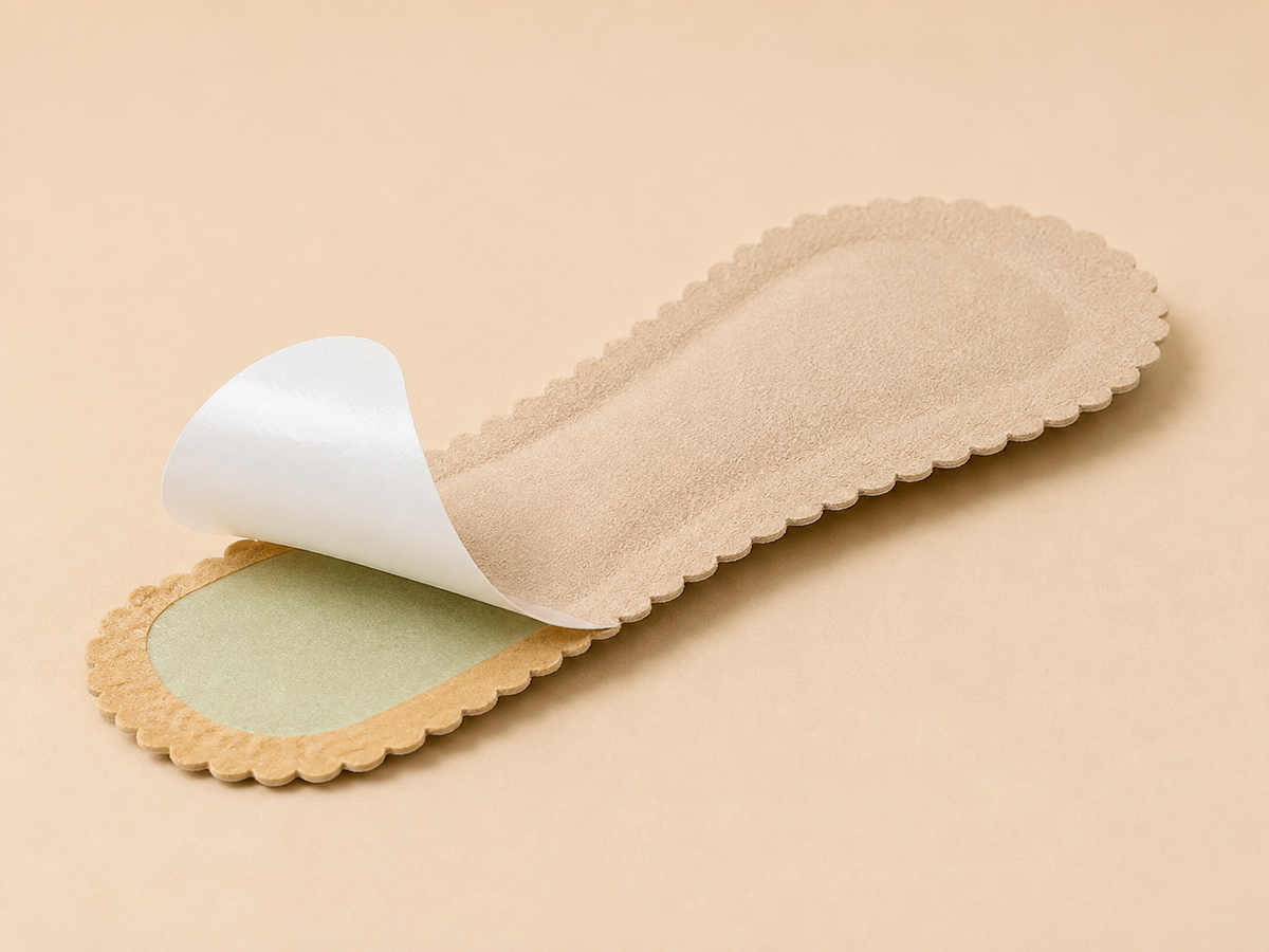Beige HeelHold three-quarter-length self-adhesive cushion pad with the release liner partially peeled